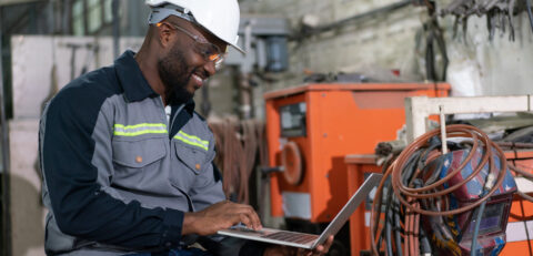 african-american-male-engineer-using-computer-laptop-control-robot-arm-welding-machine-industrial-factory